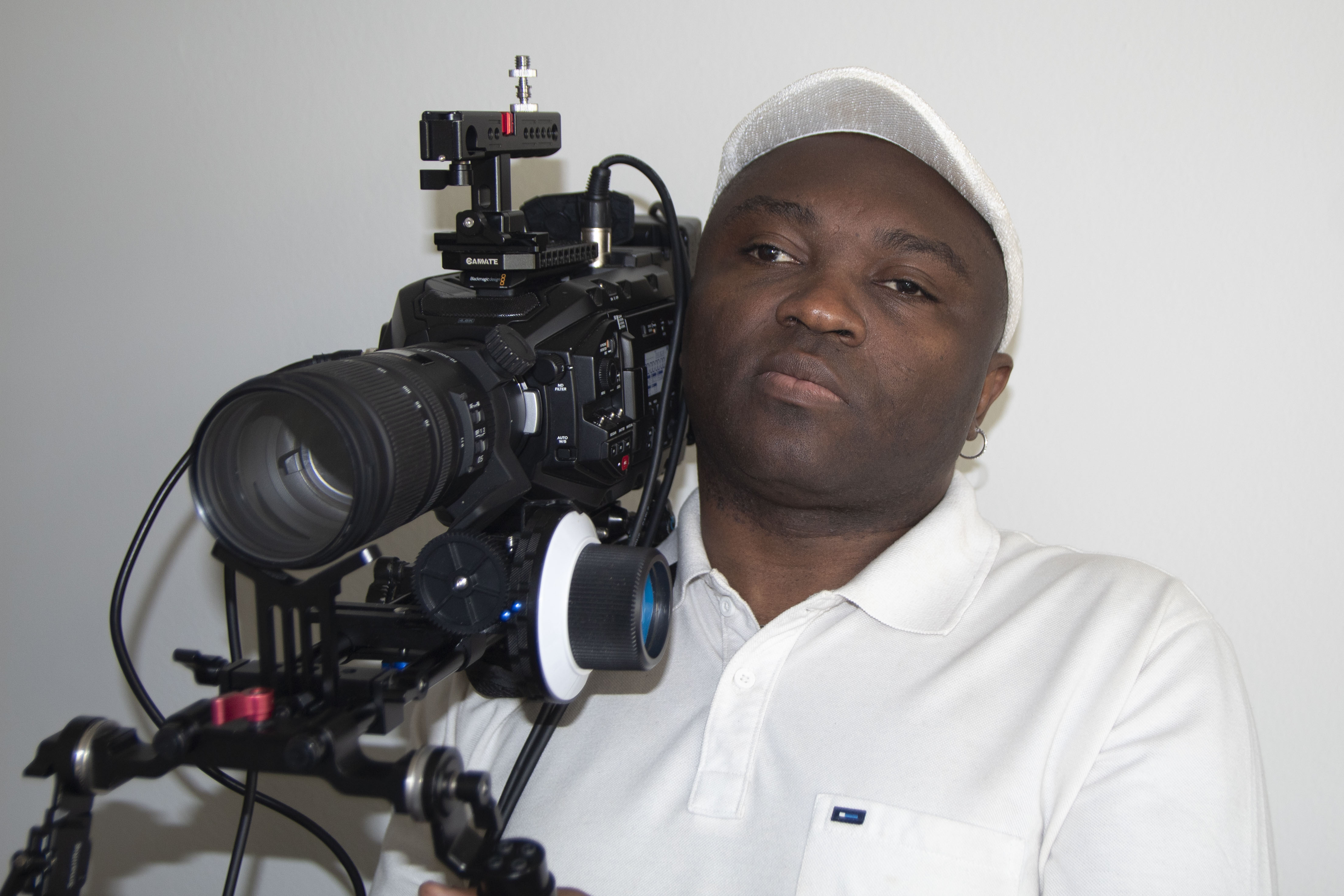 Mason Ewing, blind filmmaker, designer, and founder of A Glance into Art, holding a professional film camera on his shoulder